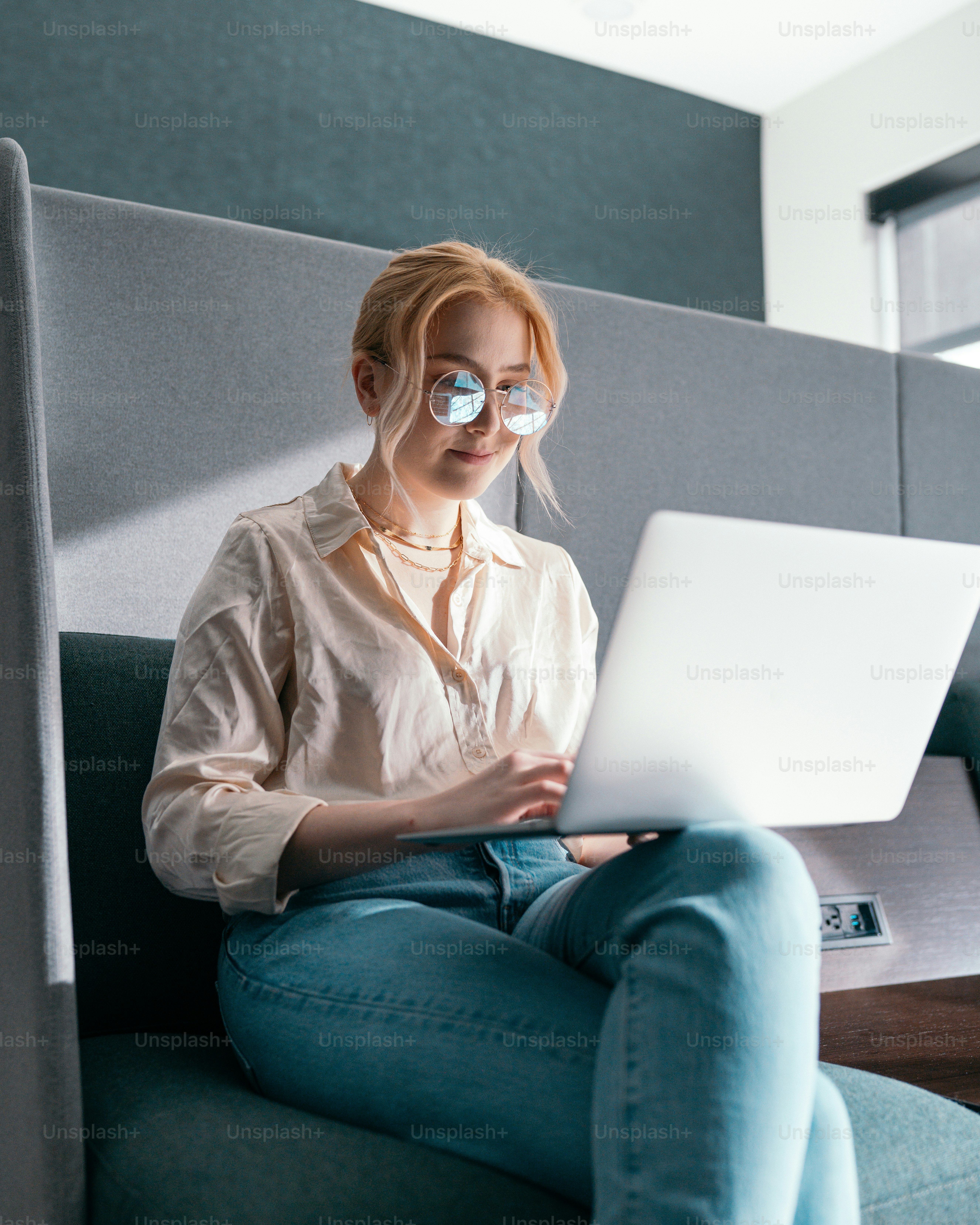 a woman sitting on a couch with a laptop