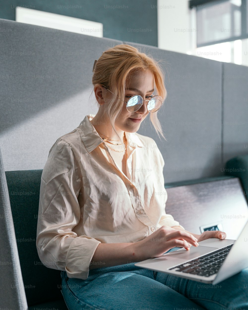 Una mujer con una máscara y usando una computadora portátil
