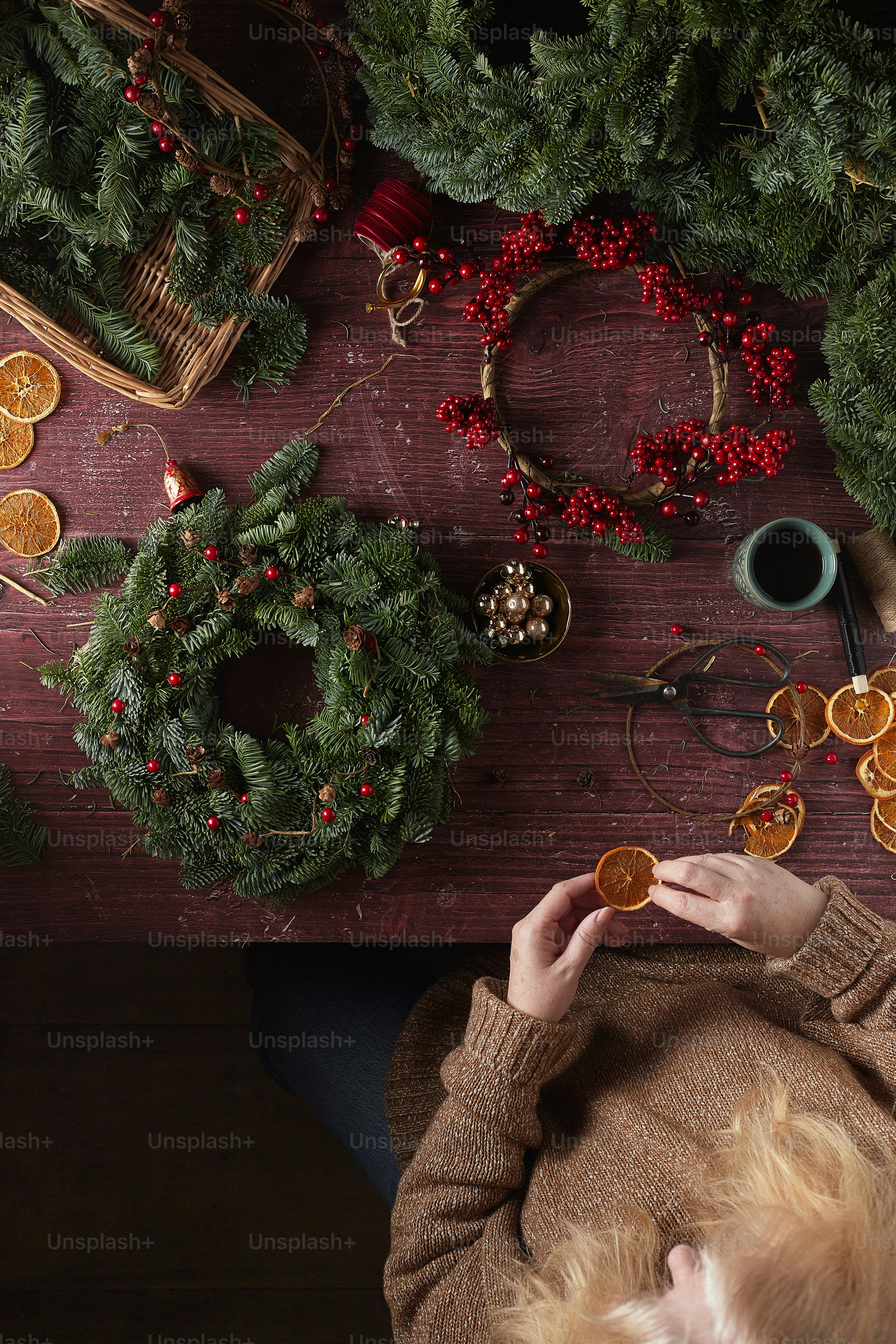 Una persona sosteniendo una galleta frente a un árbol de Navidad