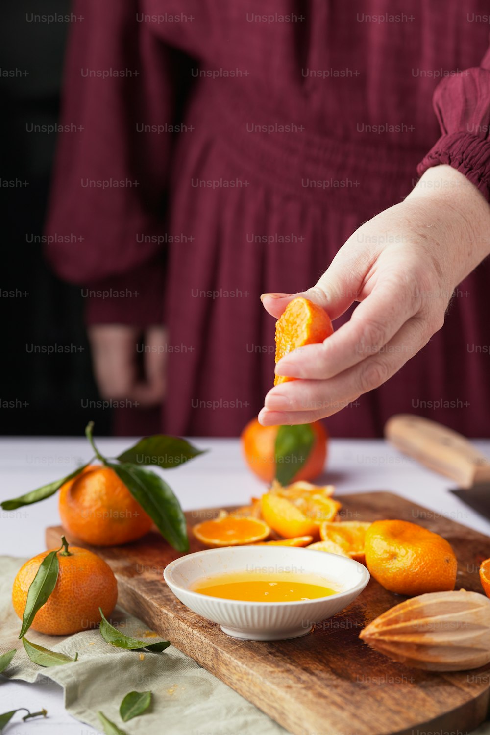 une personne mettant une orange dans un bol