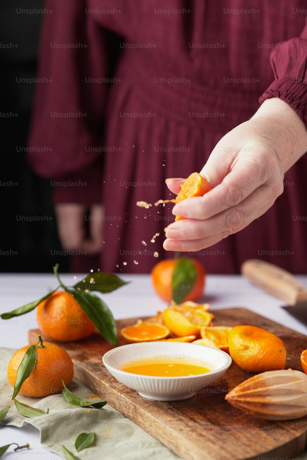 a person putting a bowl of oranges on a table