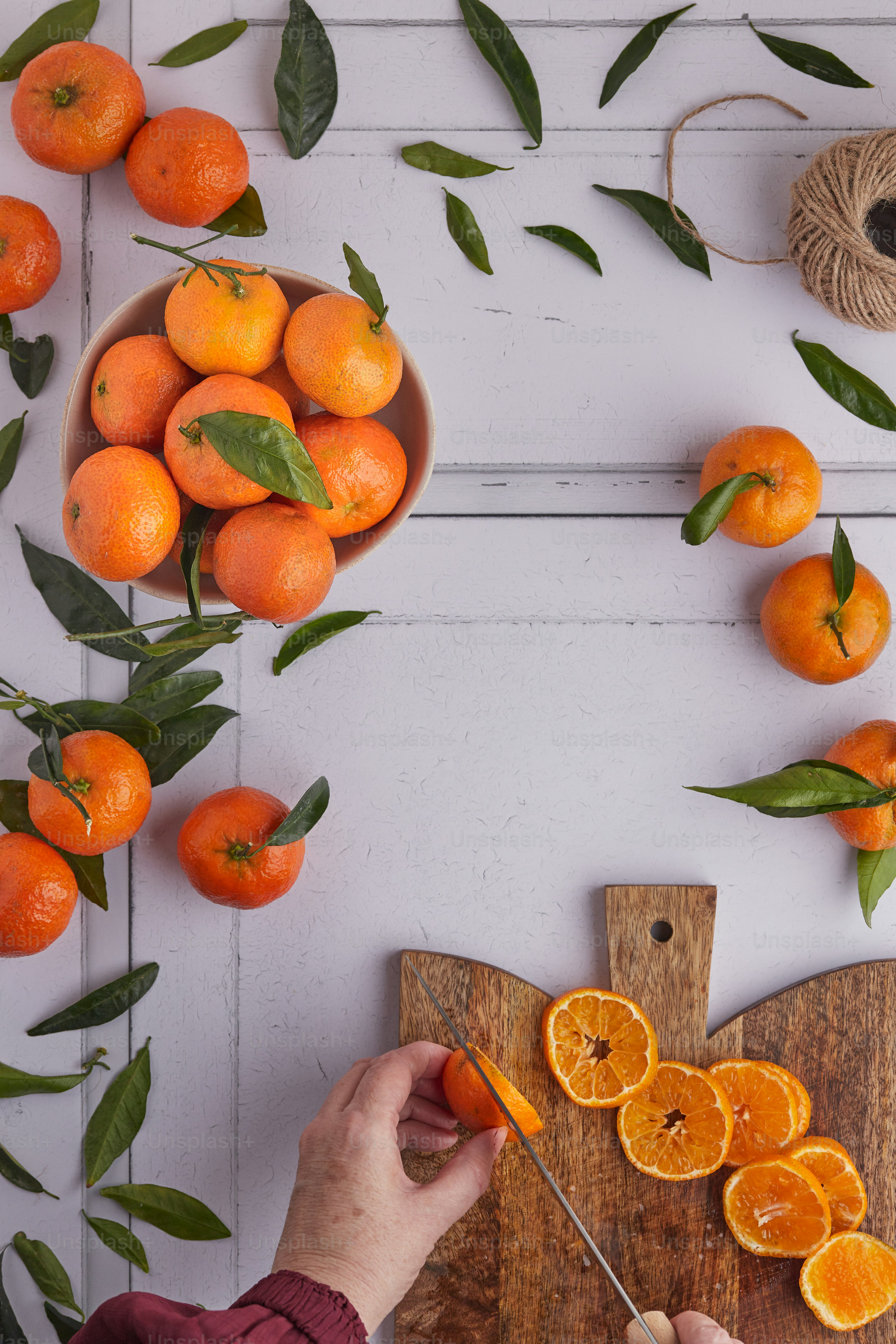 a hand holding a wooden stick with oranges on it