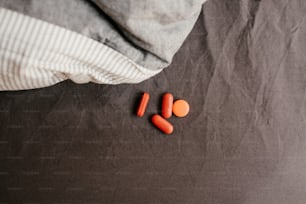 a pair of orange nail polish on a grey surface