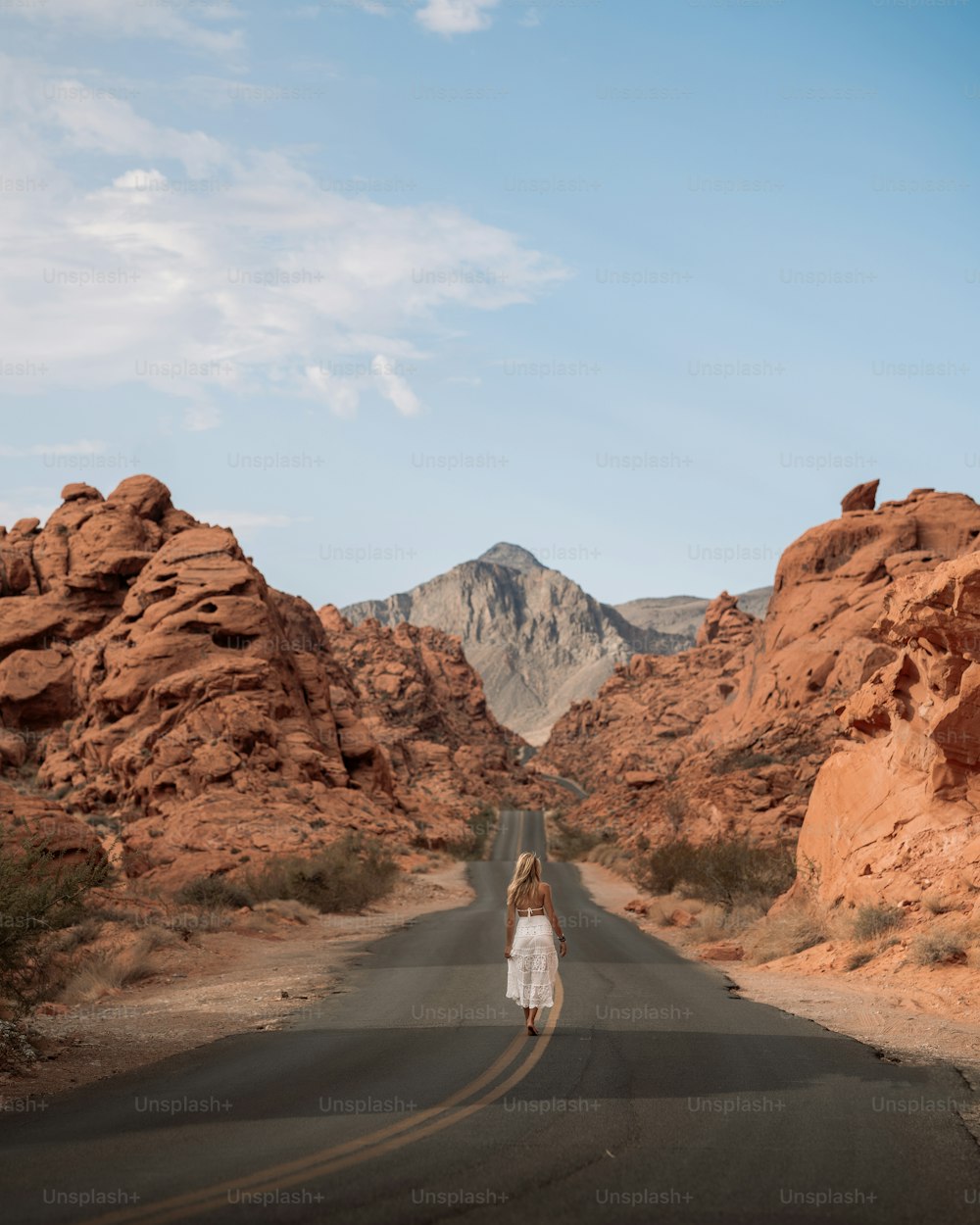 a person walking on a road in the desert