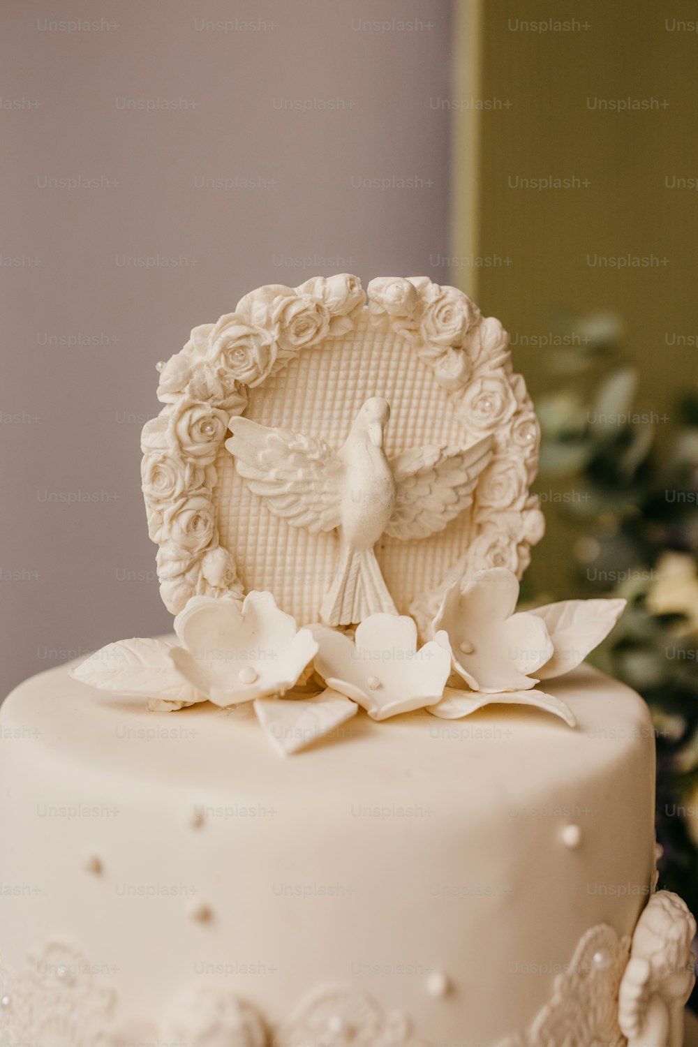 a cake with a white frosting and a white flower on top