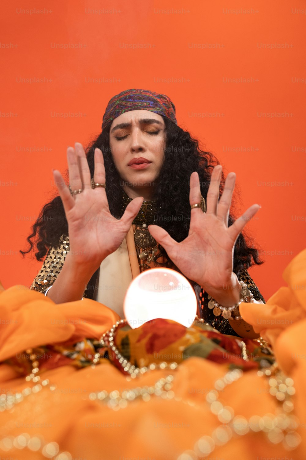 a woman wearing a headdress and holding her hands up