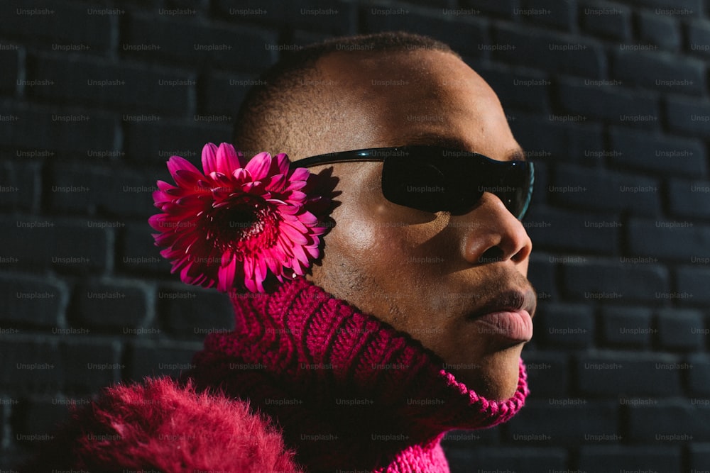 a man wearing sunglasses and a flower in his hair