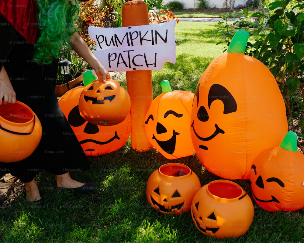 a person holding a sign with carved pumpkins