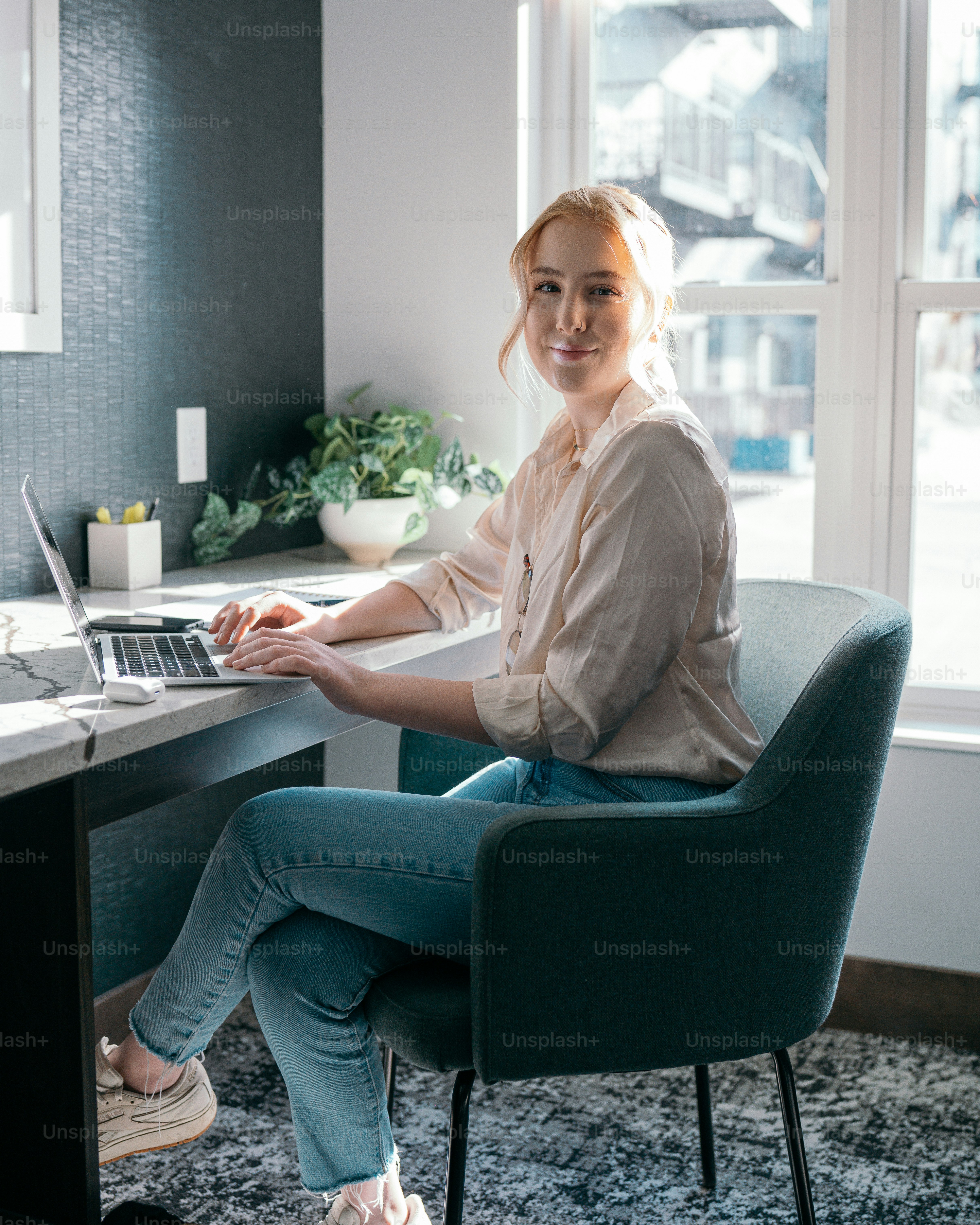 a woman sitting at a desk with a laptop