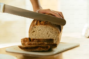 una persona cortando una hogaza de pan
