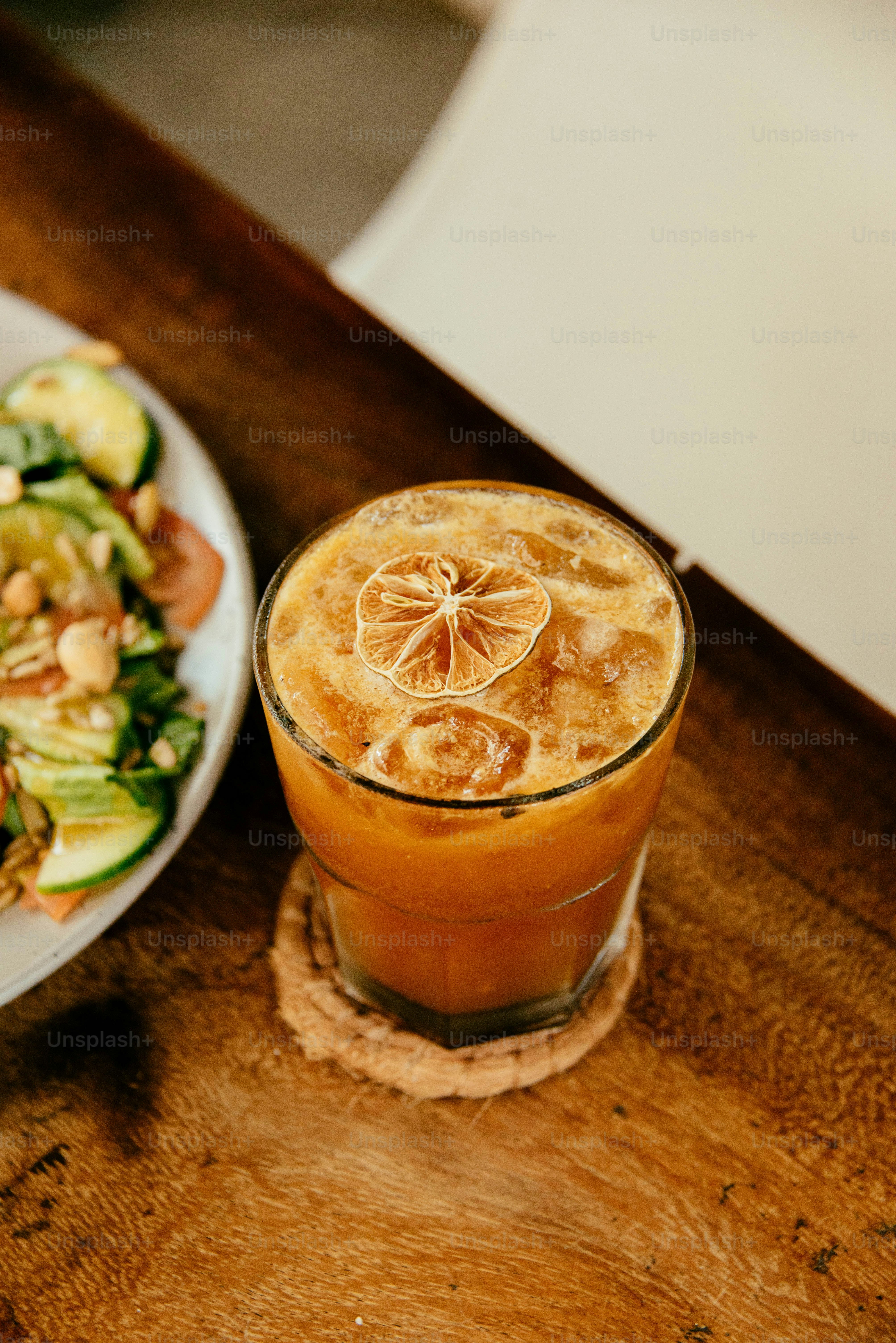 a glass of liquid with a slice of bread and a slice of bread on a wood surface