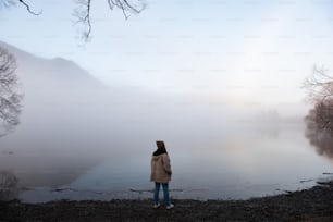 une personne debout dans un champ brumeux