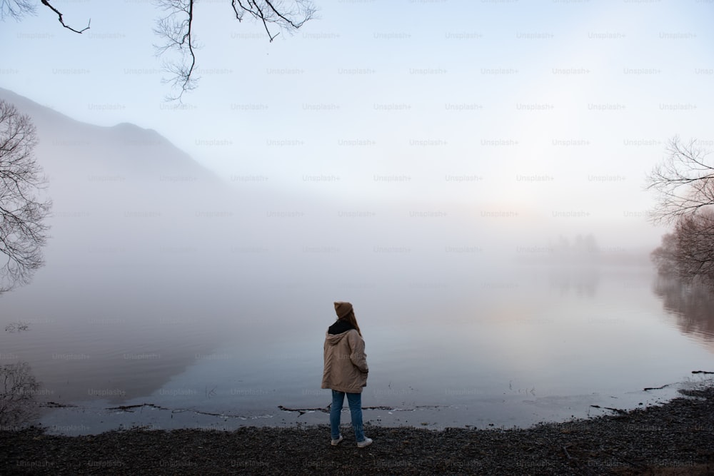 Una persona parada en un campo con niebla
