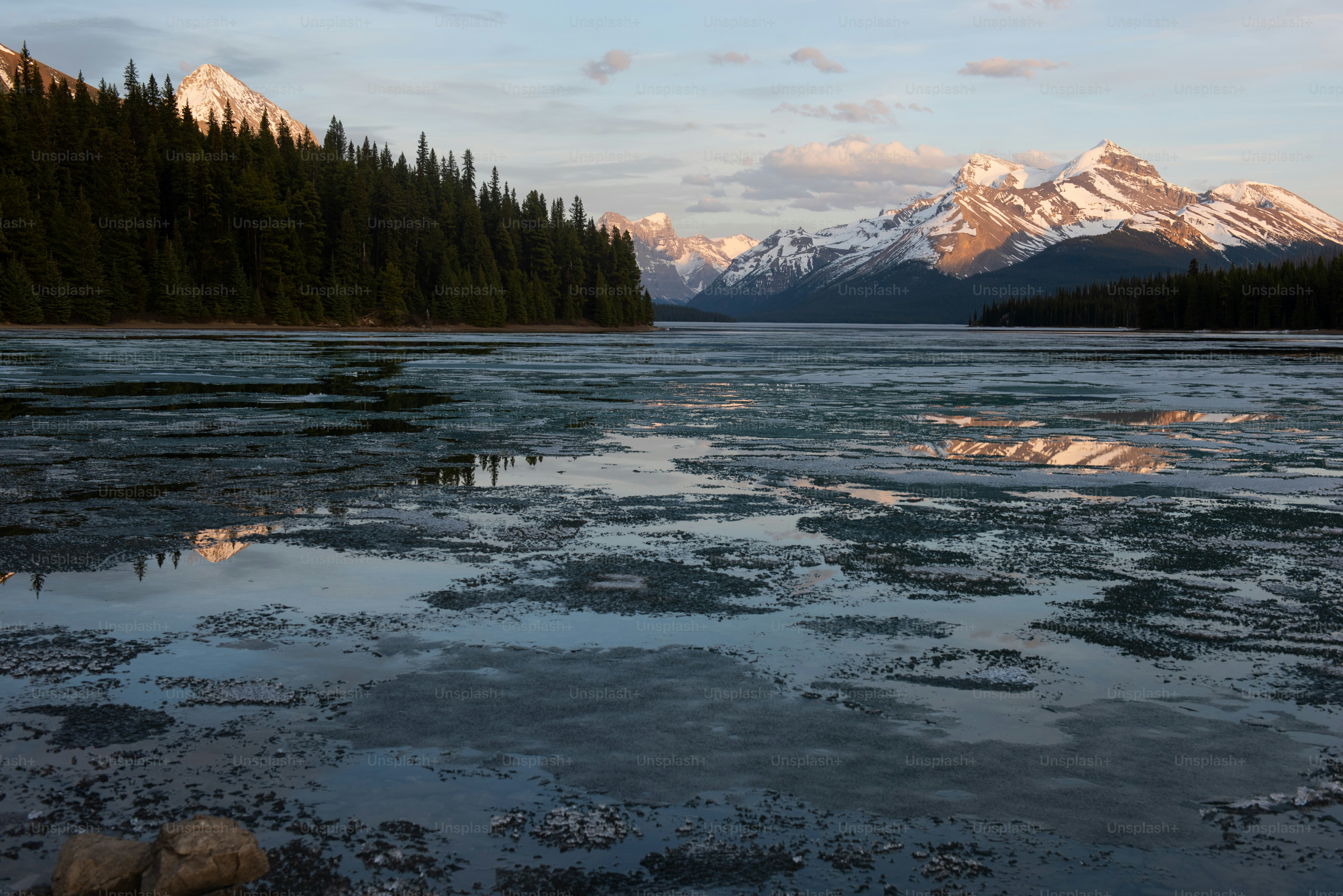 a lake with trees and mountains in the background