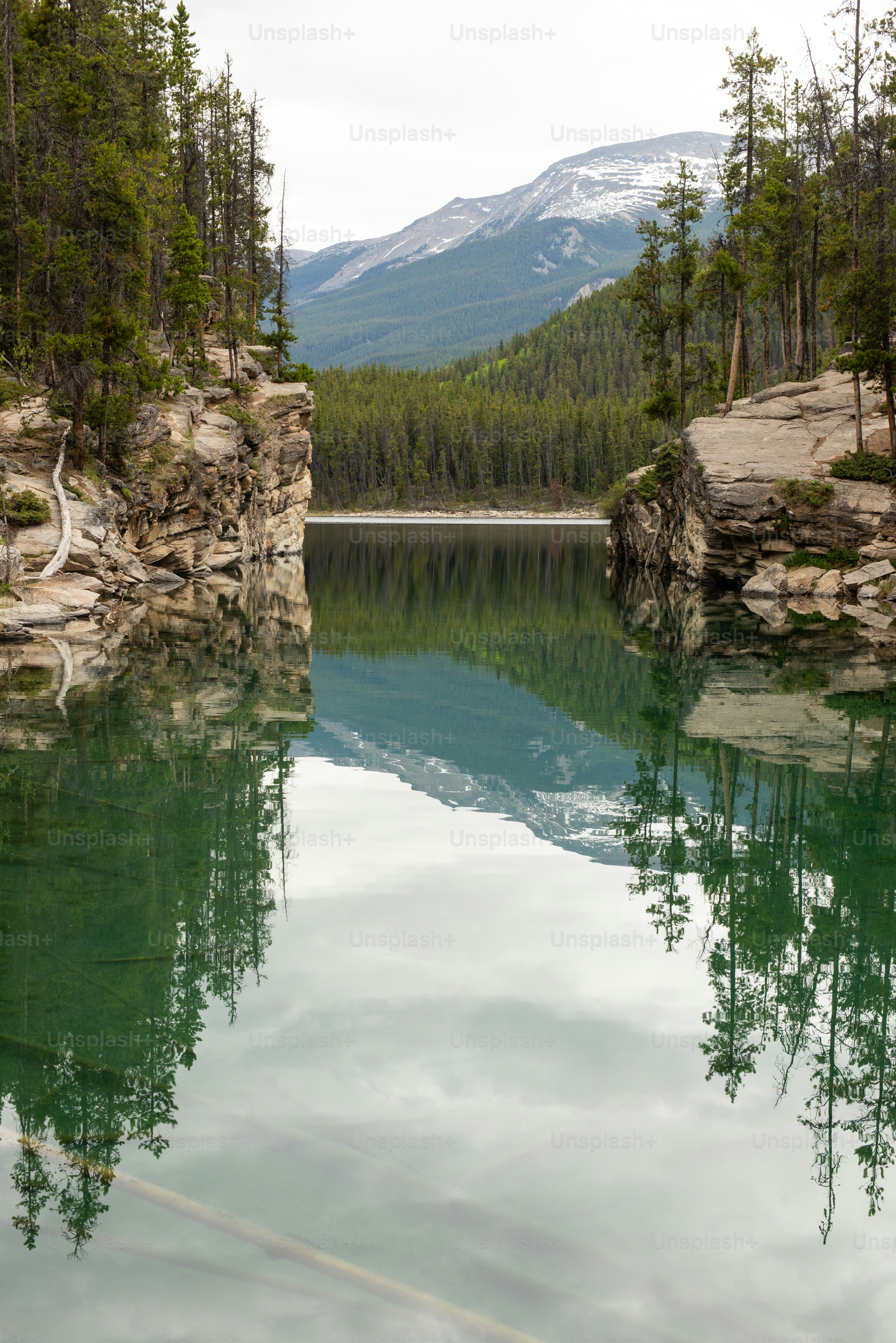 a body of water with trees and mountains in the background
