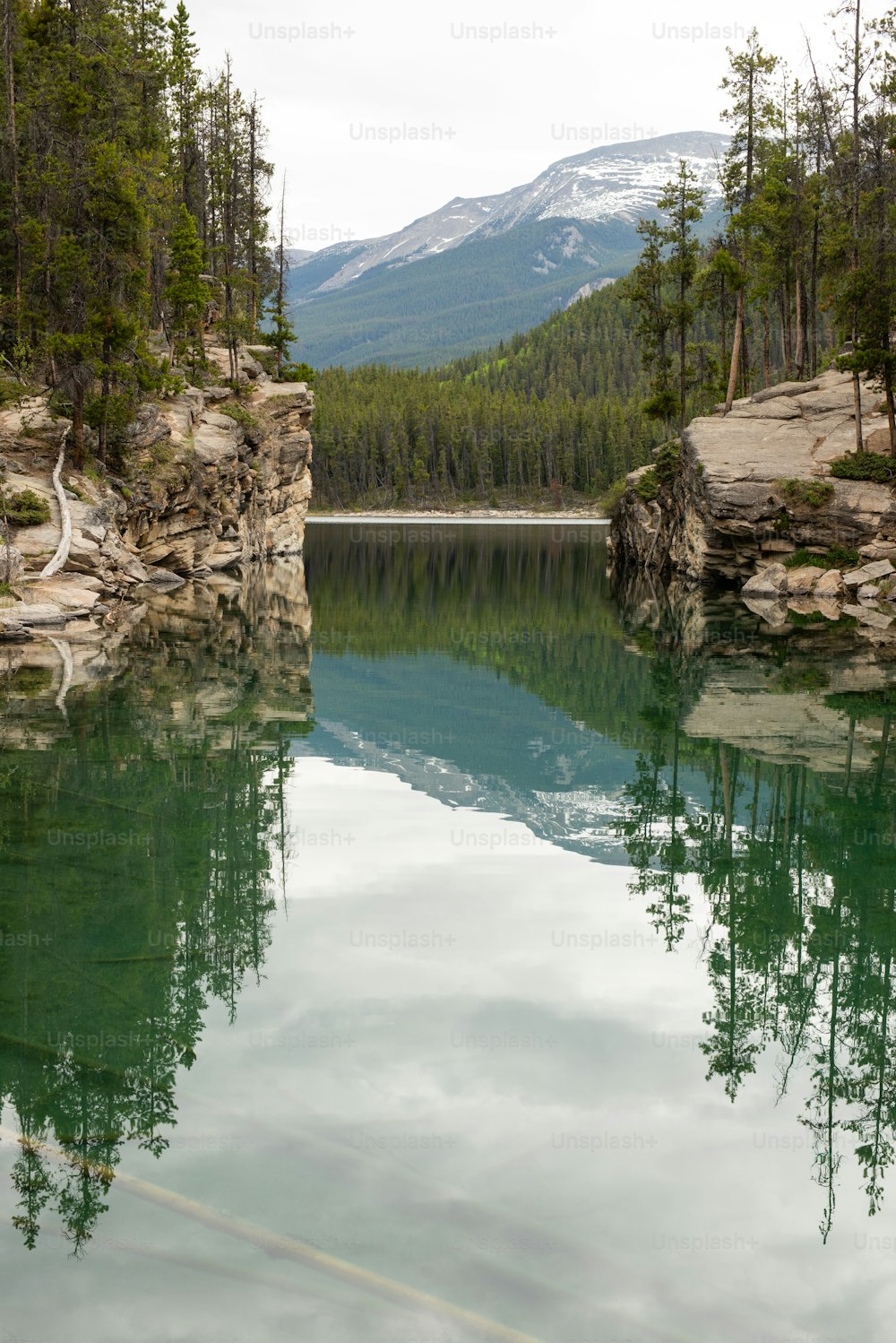 Uno specchio d'acqua con alberi e montagne sullo sfondo