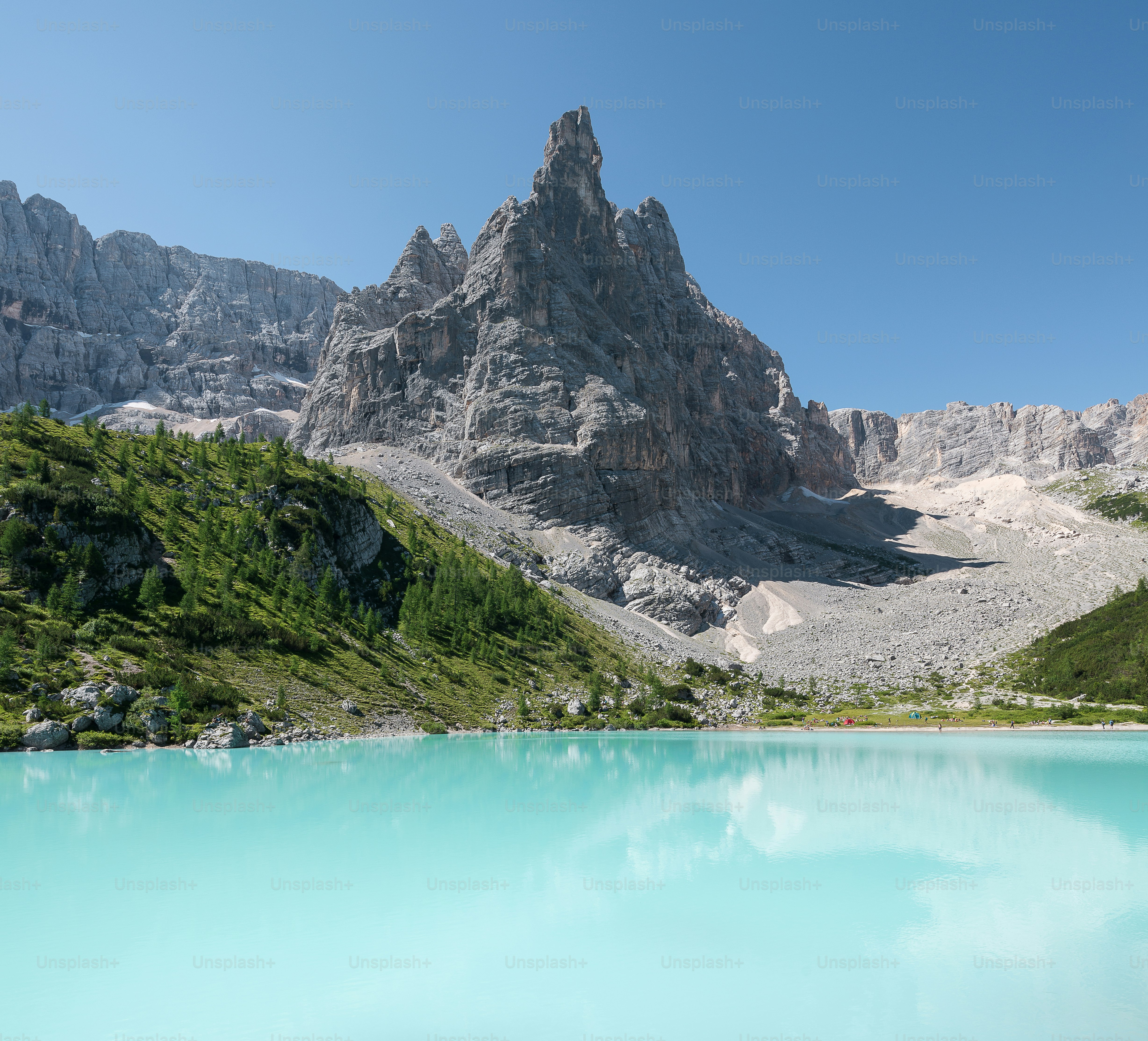 A mountain with a body of water below photo – Image on Unsplash