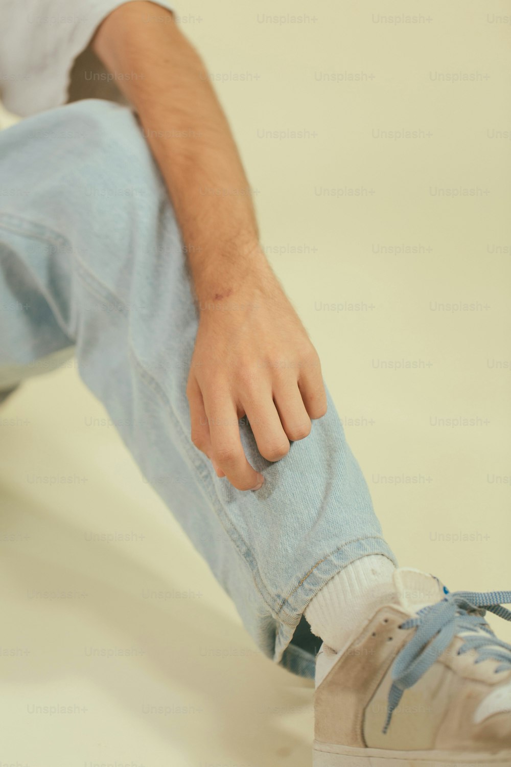 Un homme assis par terre avec son pied sur une planche à roulettes