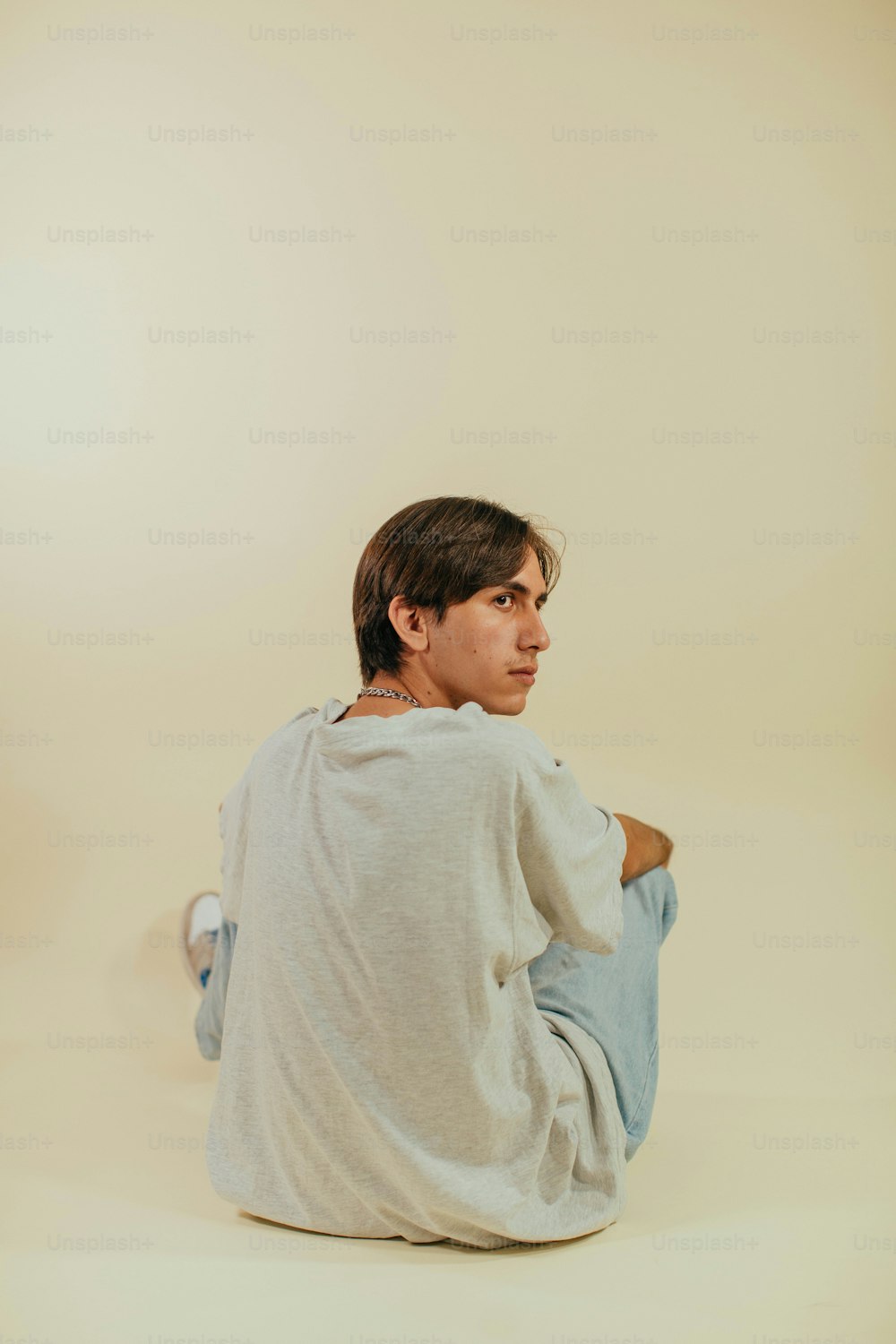 a man sitting on a white surface