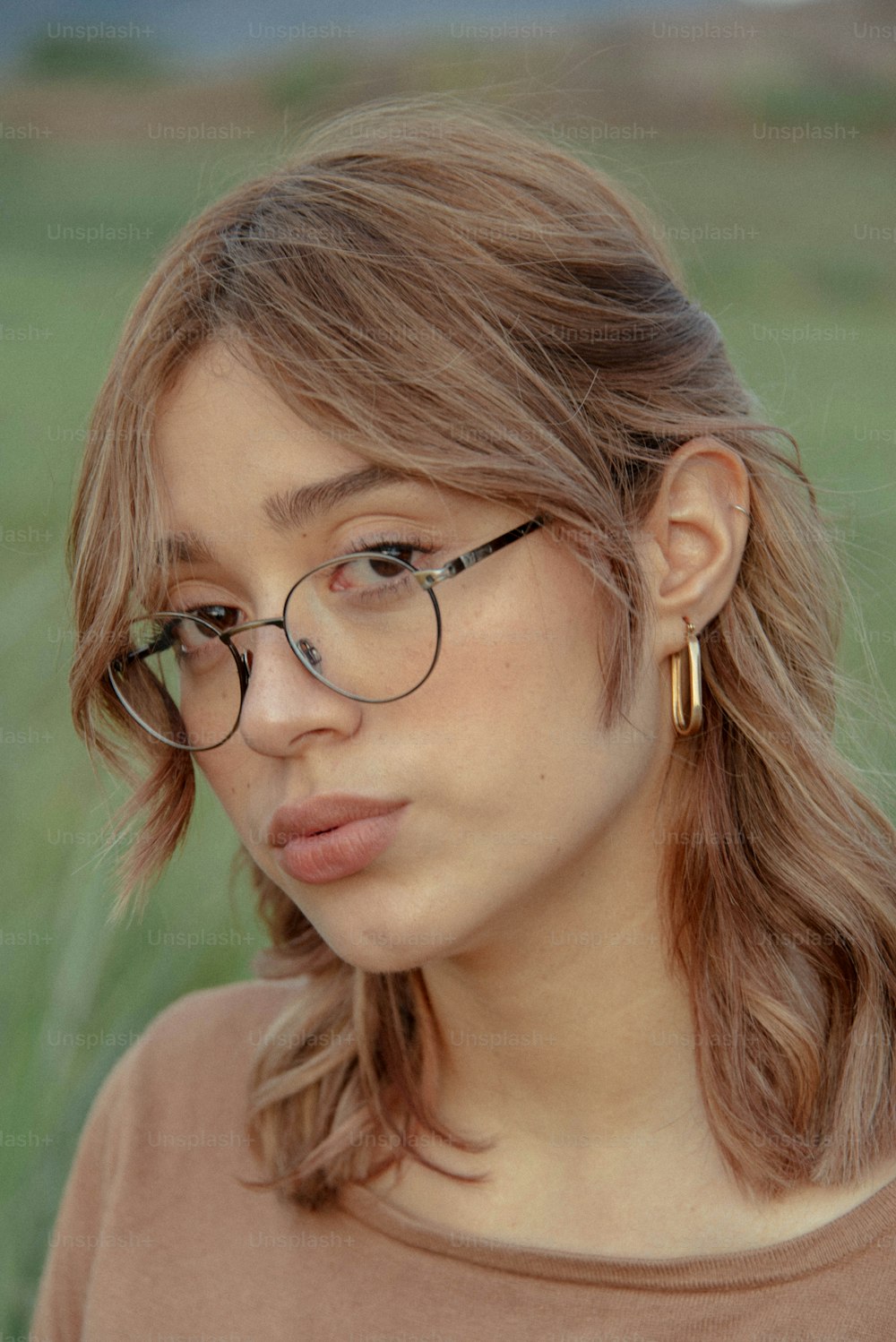a woman with glasses sticking her tongue out