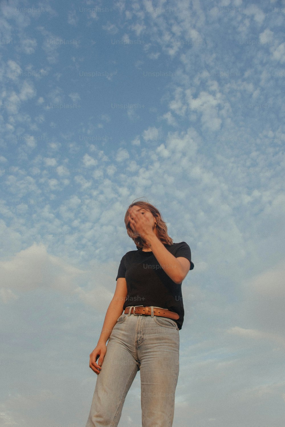 une personne debout devant un ciel nuageux