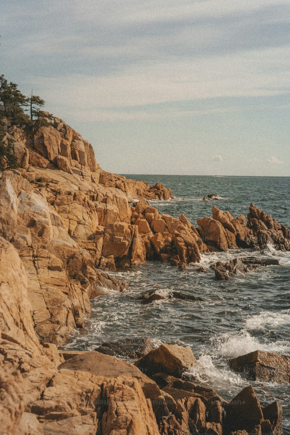 una spiaggia rocciosa con onde che si infrangono contro di essa