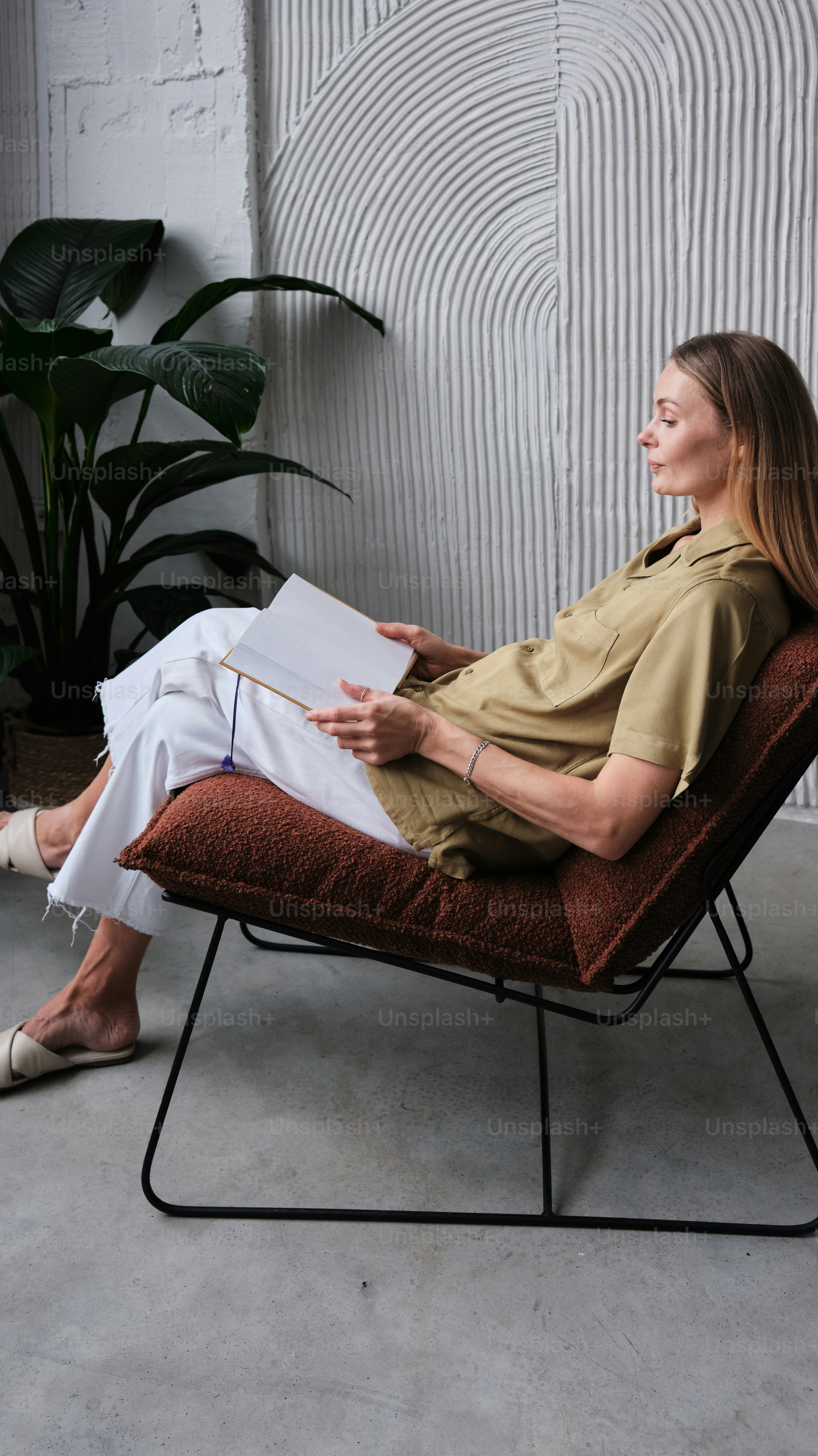 a person sitting on a chair reading a book