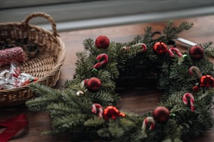 a small christmas tree with a basket of red and white ornaments