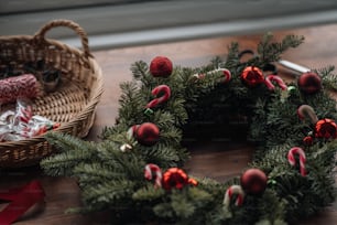 Un pequeño árbol de Navidad con una cesta de adornos rojos y blancos