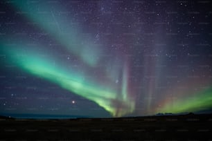 a green and purple aurora in the sky
