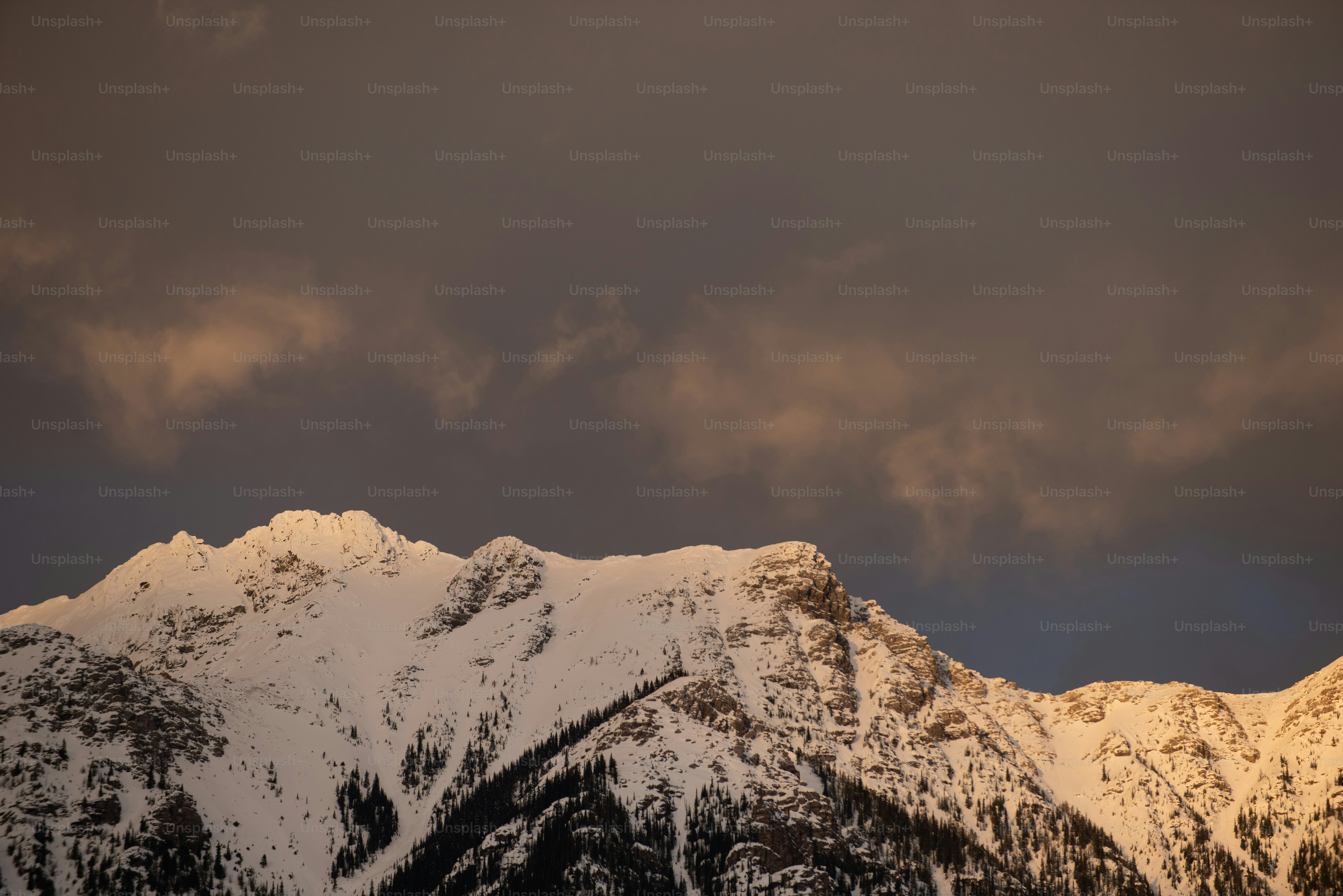 Una montagna innevata con le nuvole