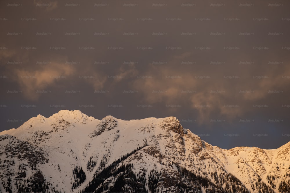 a snowy mountain with clouds