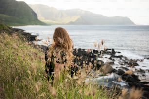 a person sitting on a rock by the water