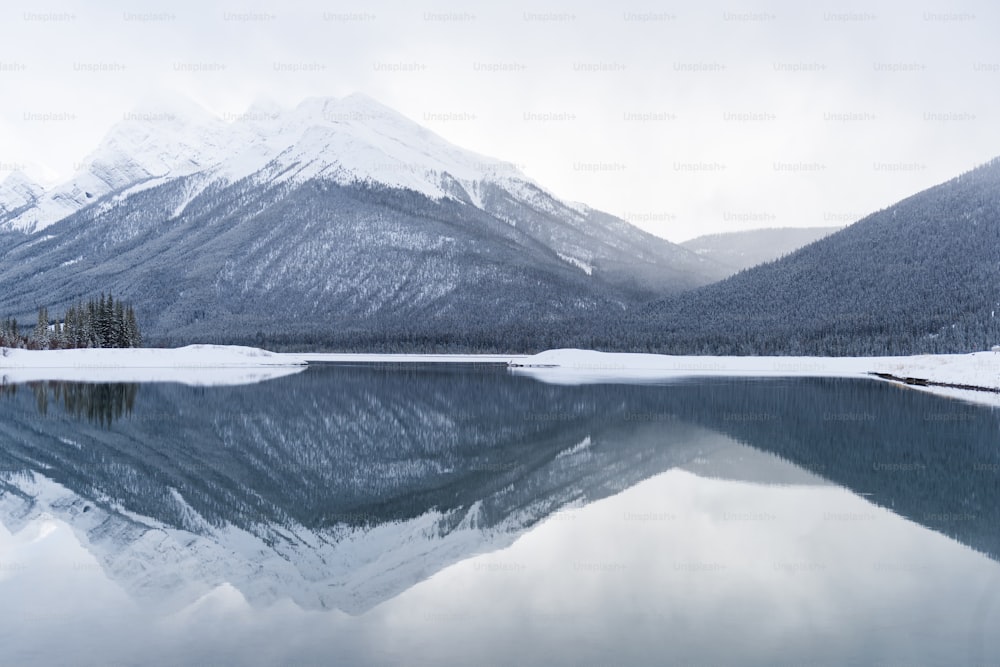 a lake with snow and mountains in the background