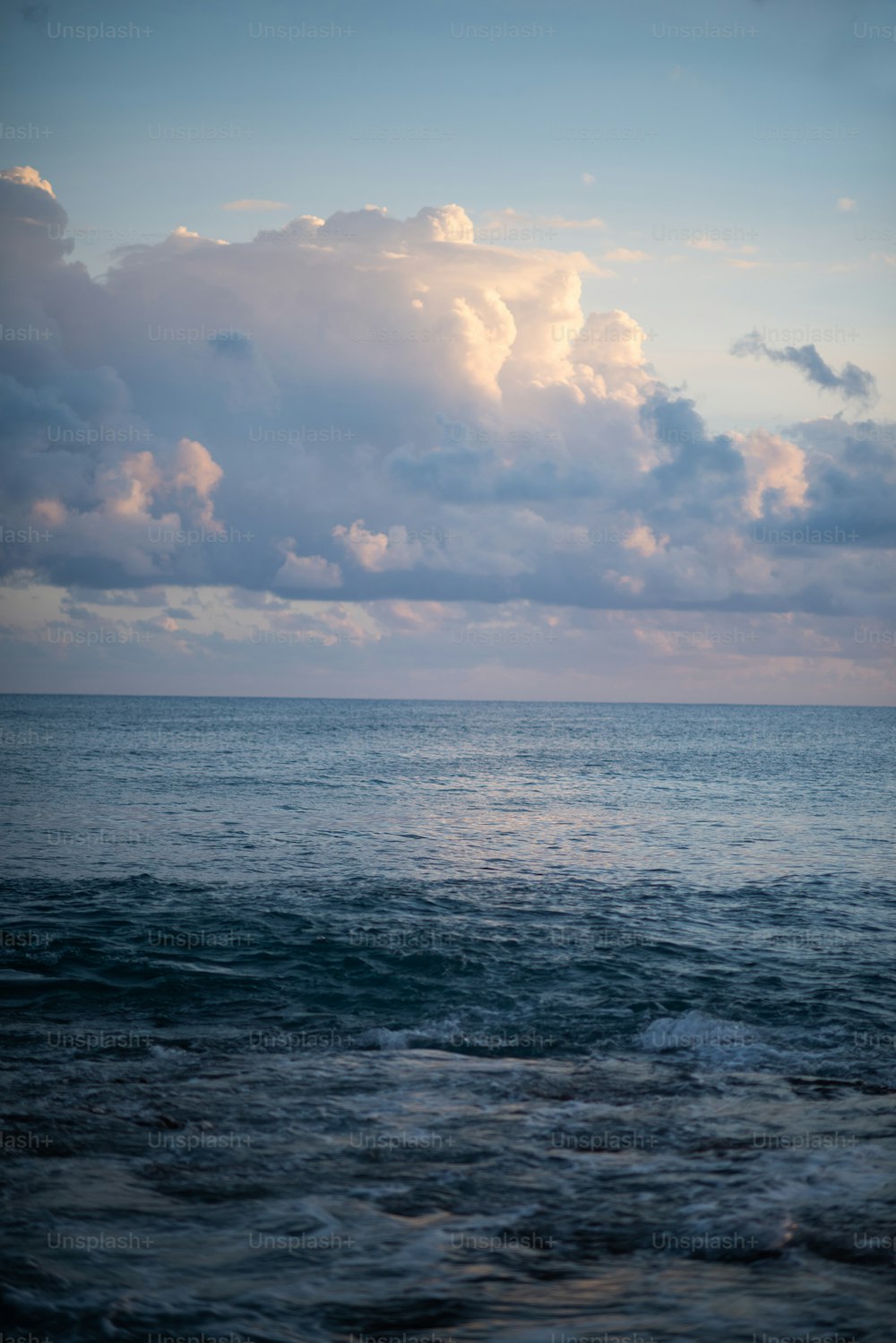 a body of water with clouds above it