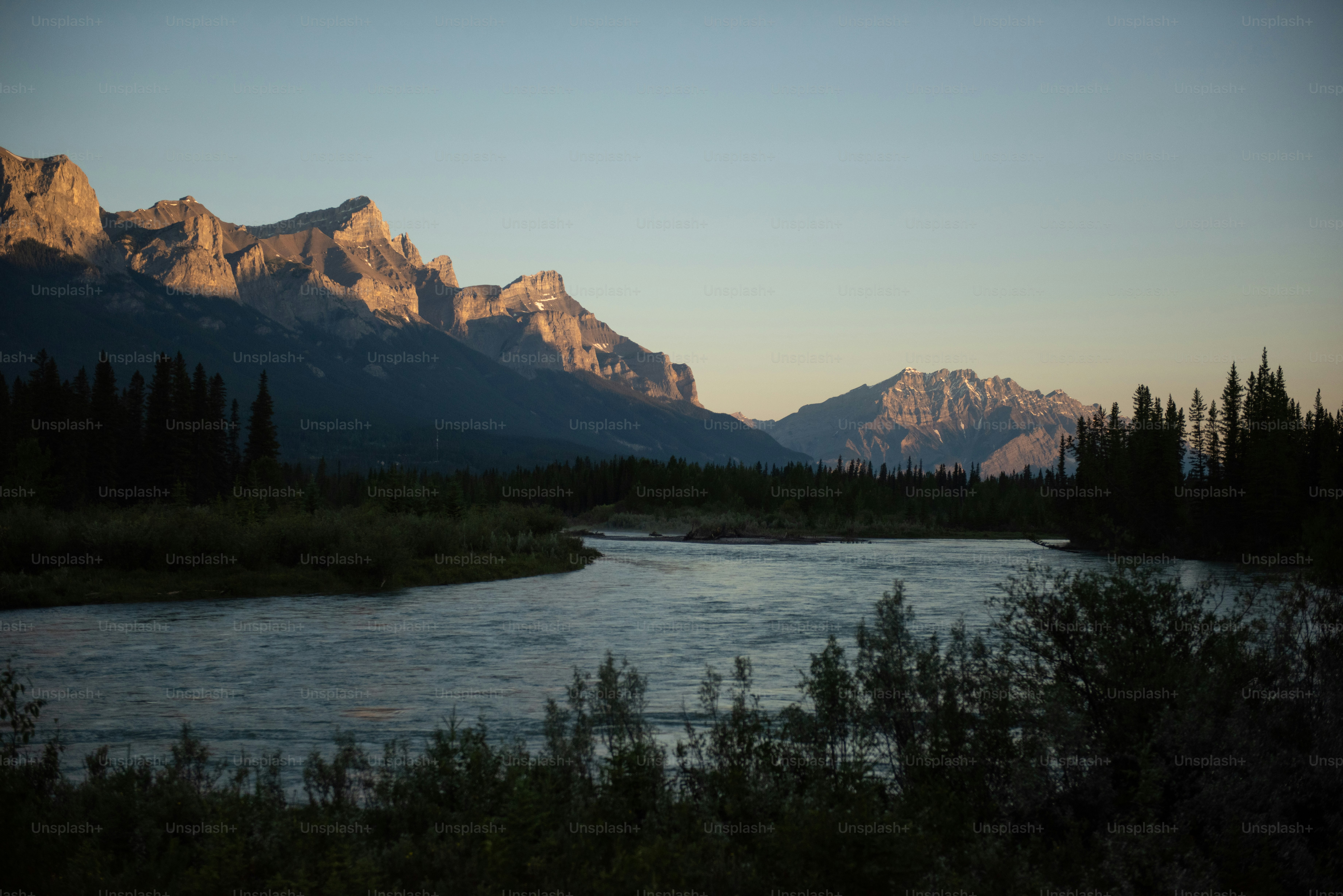 a lake with trees and mountains in the background