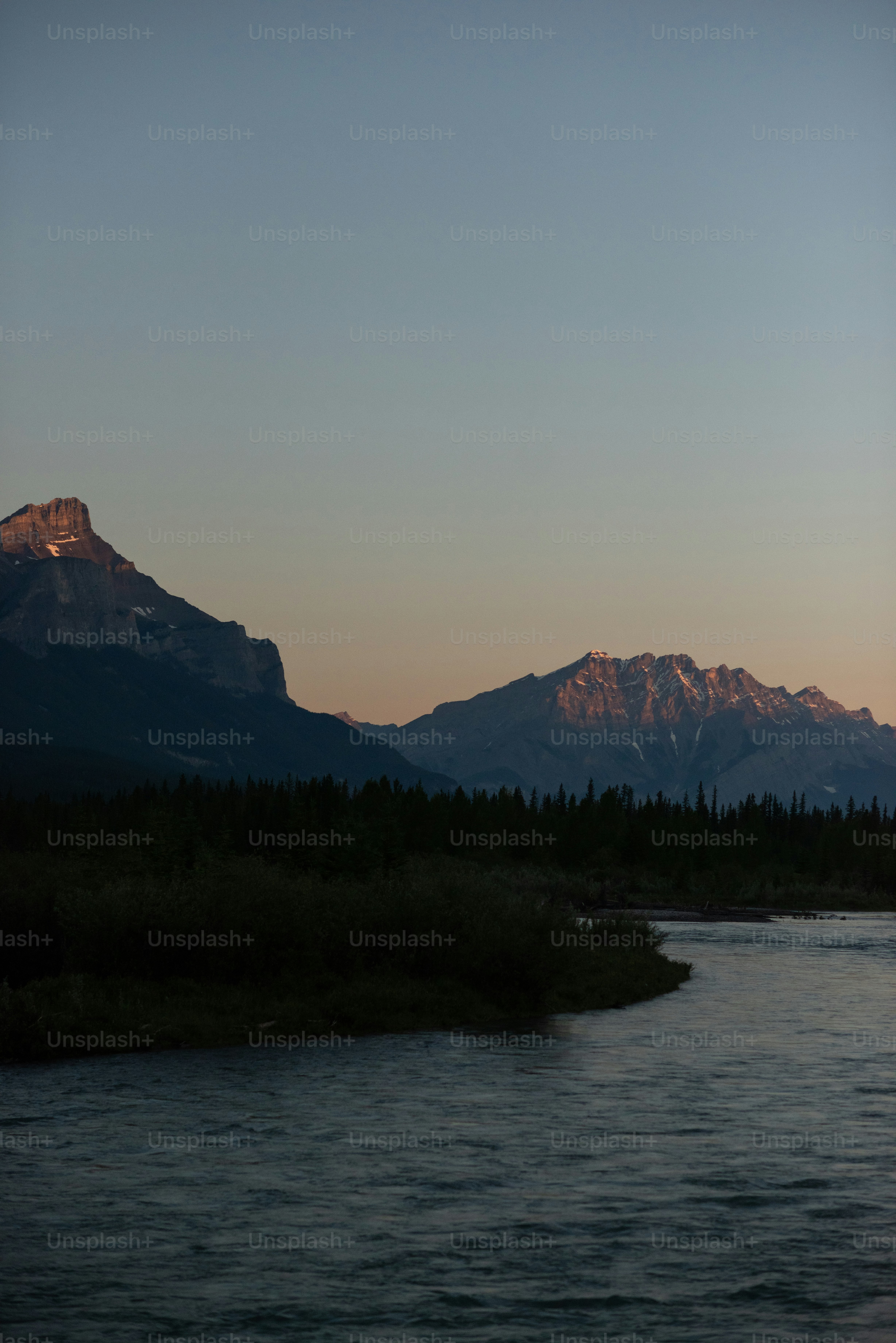 a body of water with trees and mountains in the background
