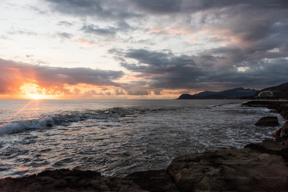 a rocky beach with a sunset