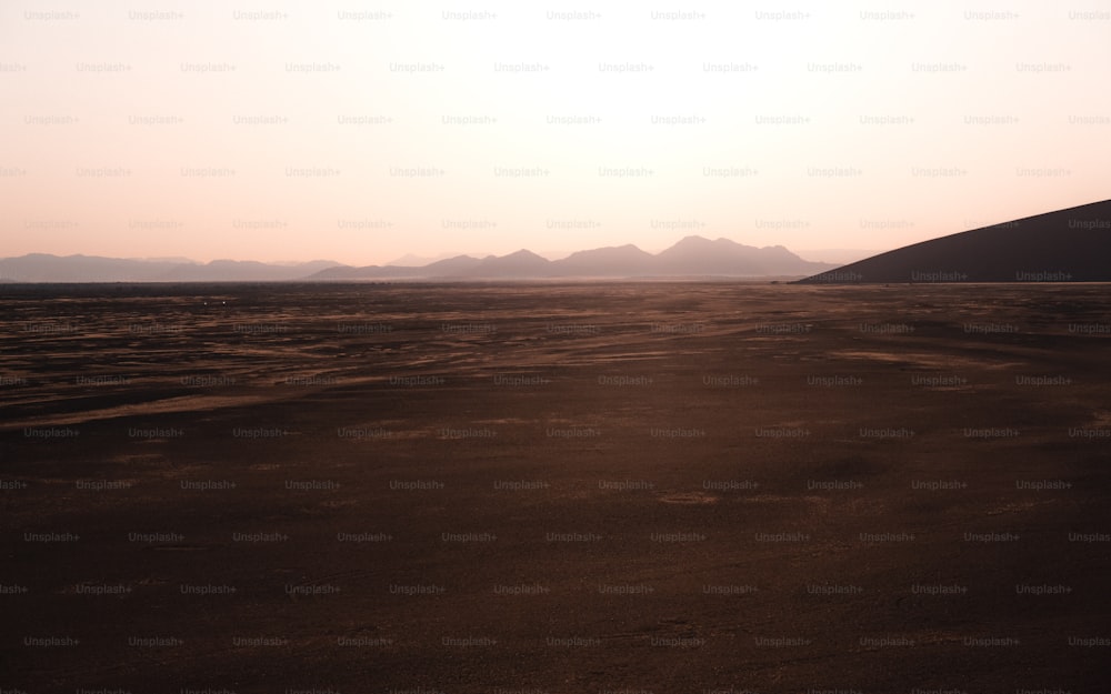 a large flat area with hills in the background
