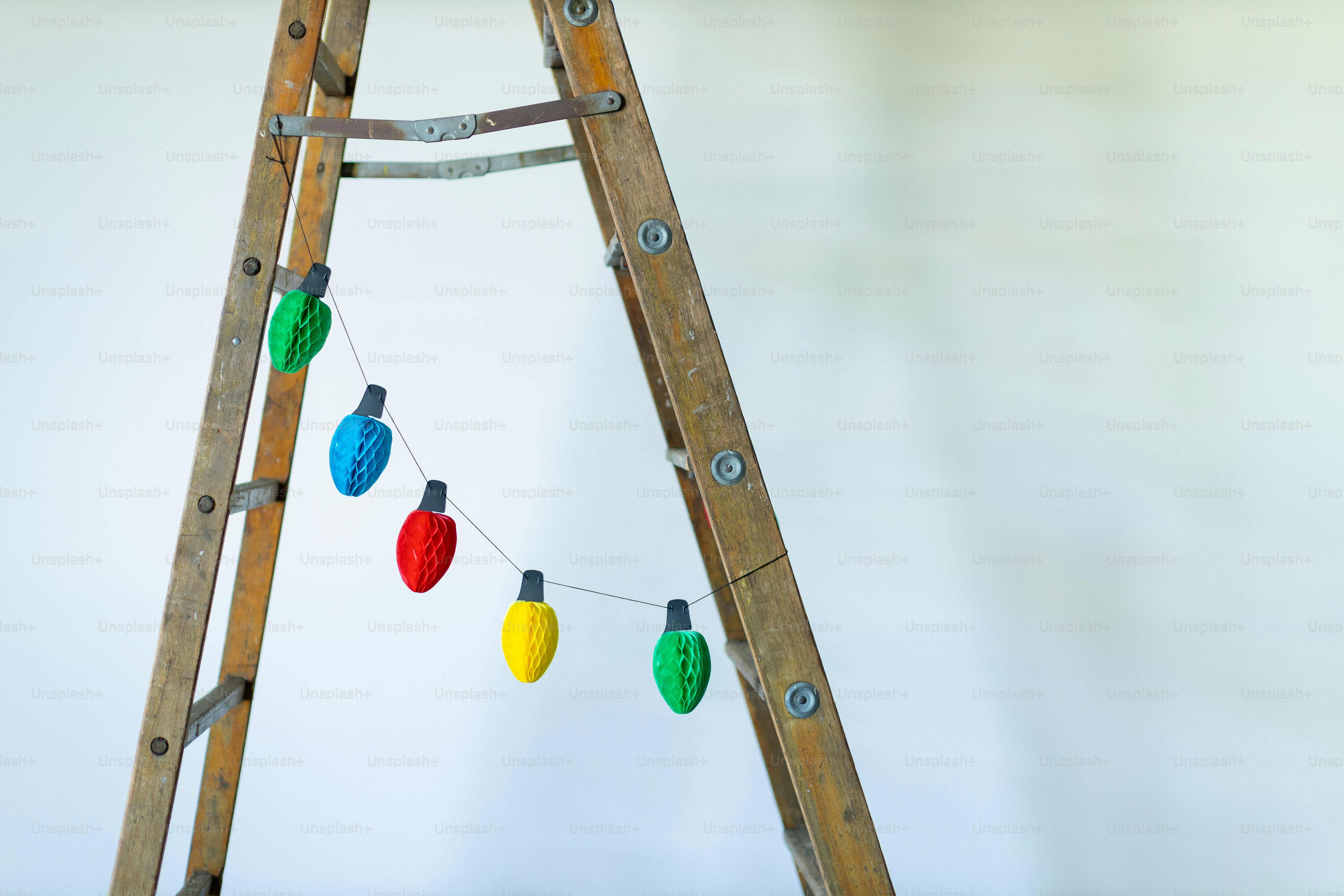 a wooden pole with a few colorful balls from it