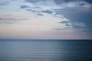 a body of water with clouds above it