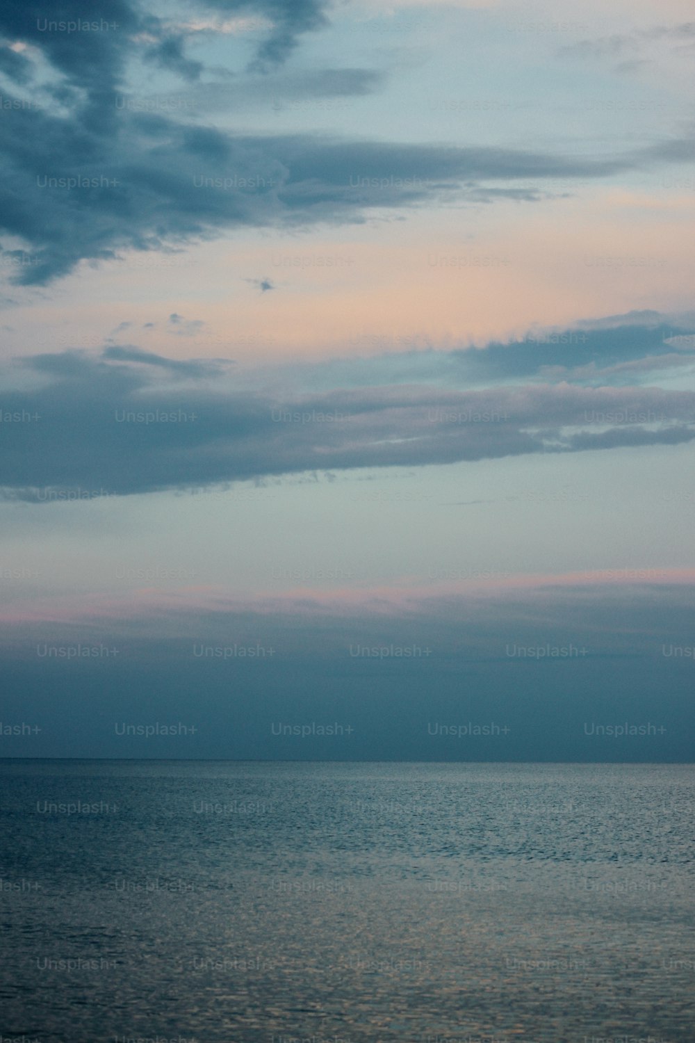 a body of water with clouds above it