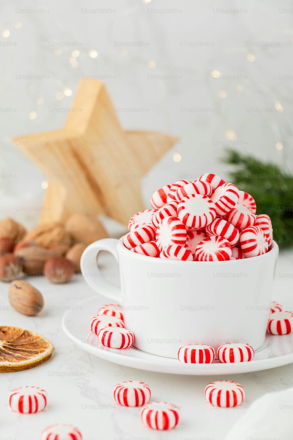 una taza de té con un glaseado rojo y blanco en un plato blanco con galletas y un