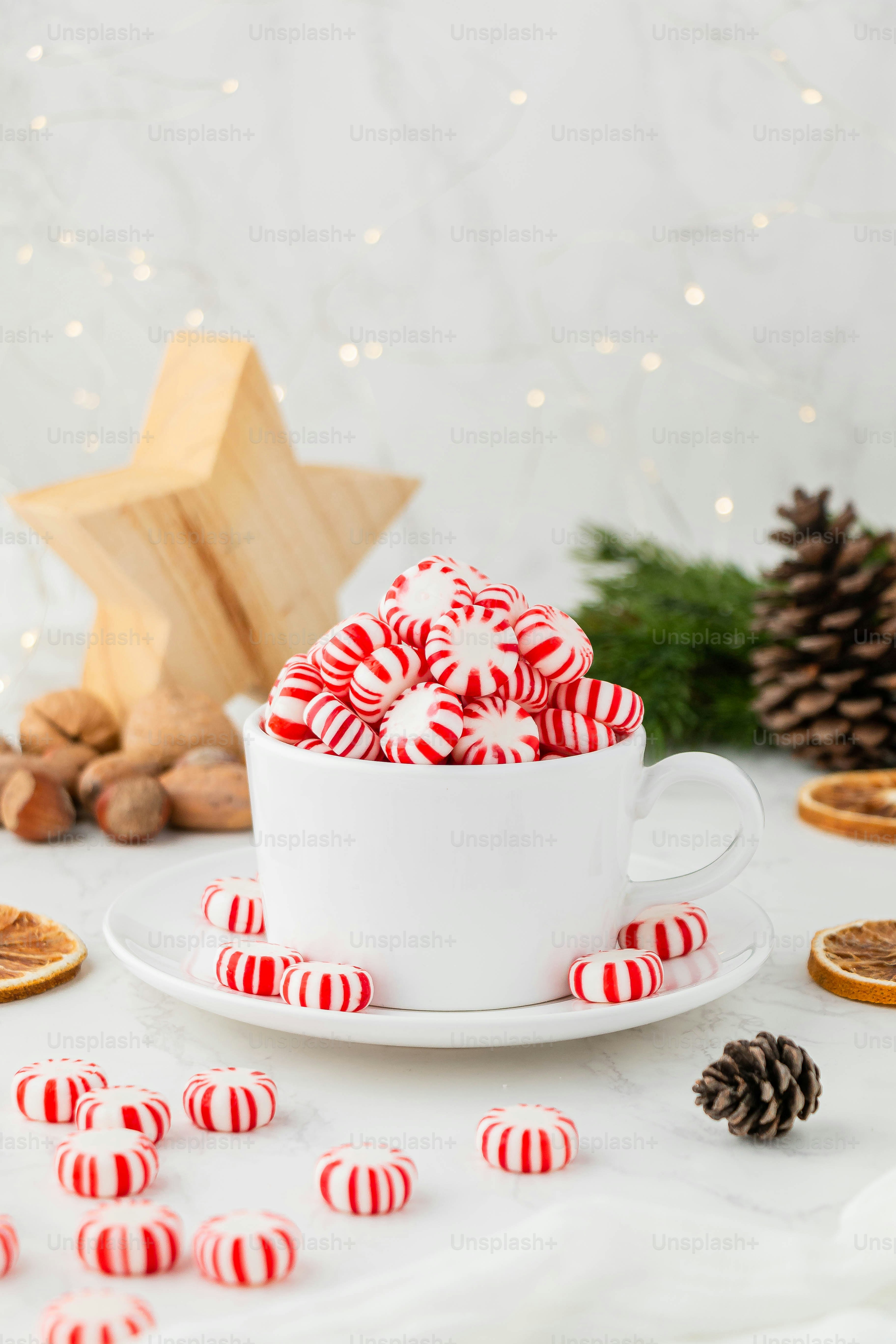 eine Tasse Kaffee mit rot-weißem Zuckerguss auf einem weißen Teller mit einer weißen Tasse