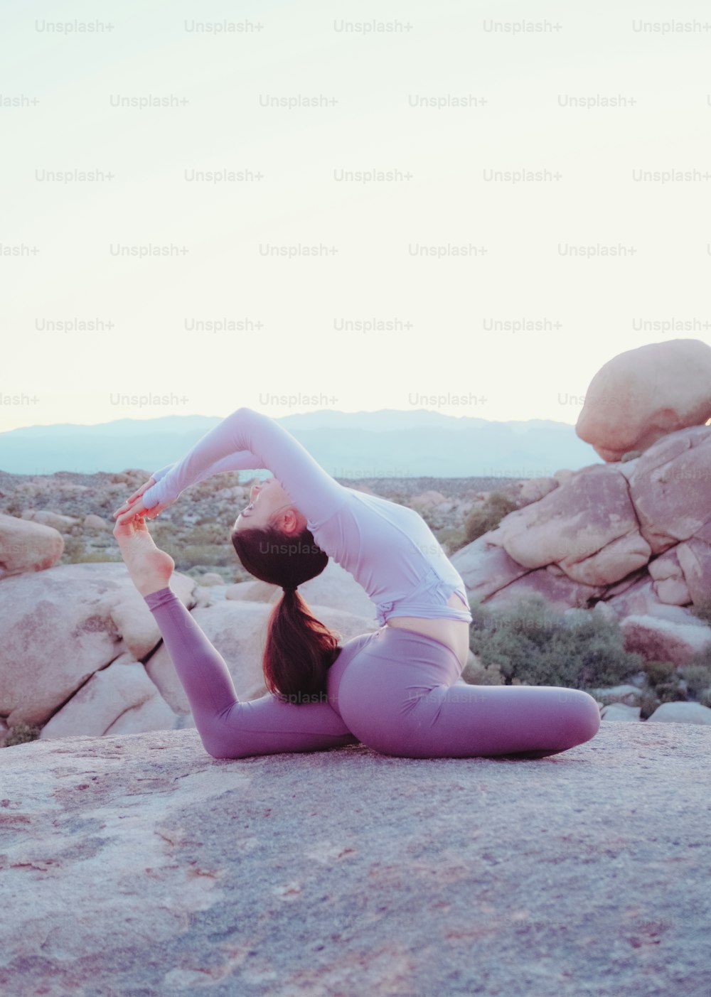 a person doing yoga on a rock