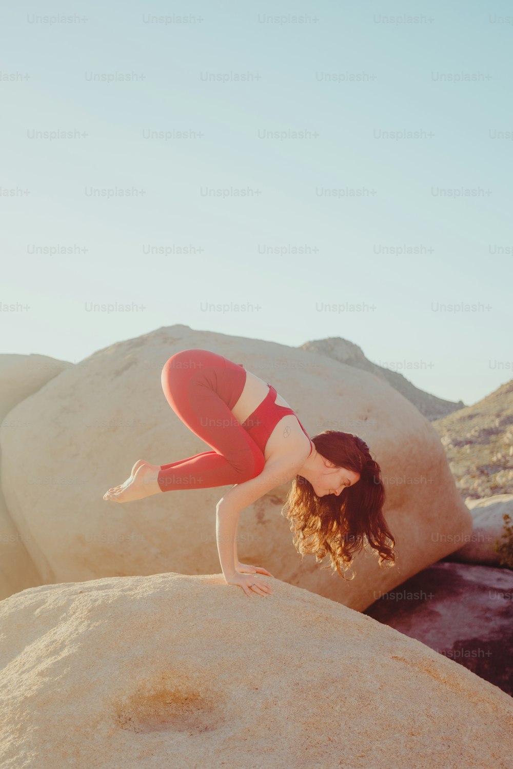 a person in a red dress lying on a rock