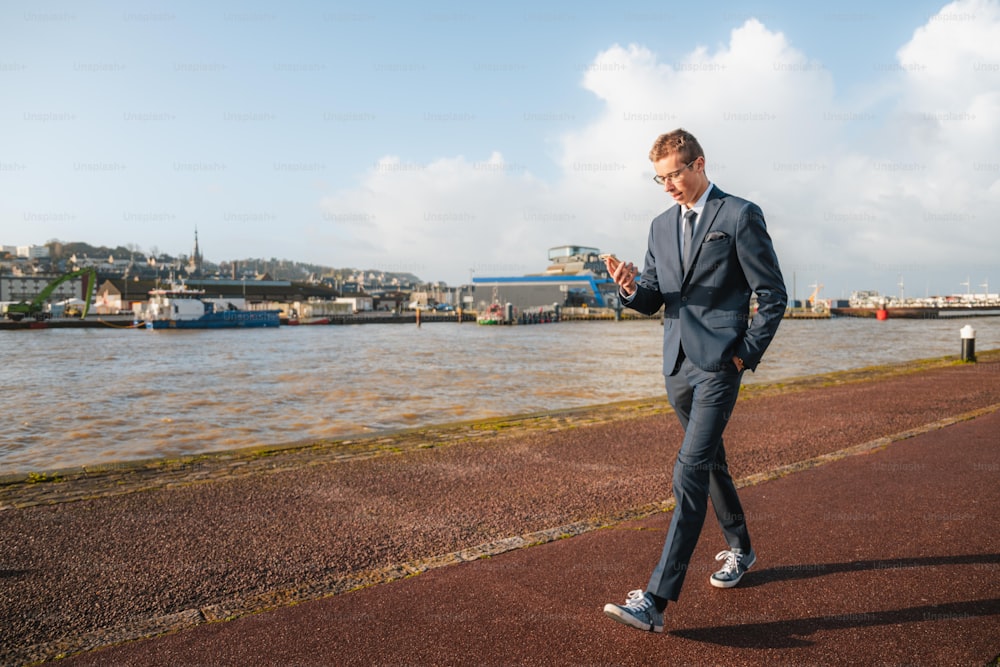 a man standing on a sidewalk near a body of water