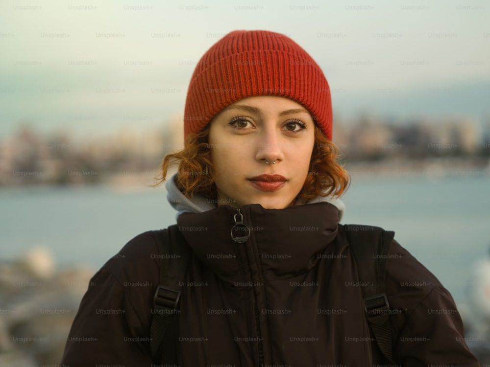 a person wearing a red beanie and a black jacket