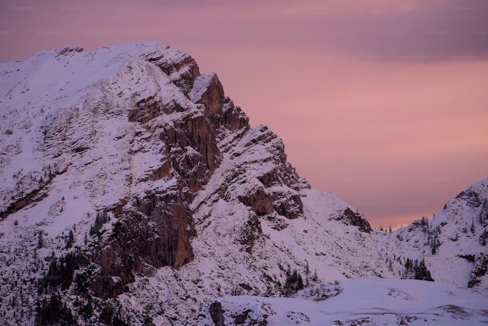 Una montaña nevada con un cielo púrpura