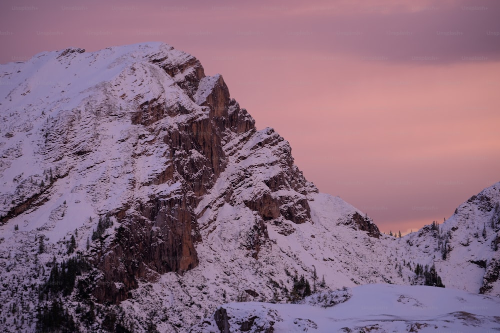 a snowy mountain with a purple sky